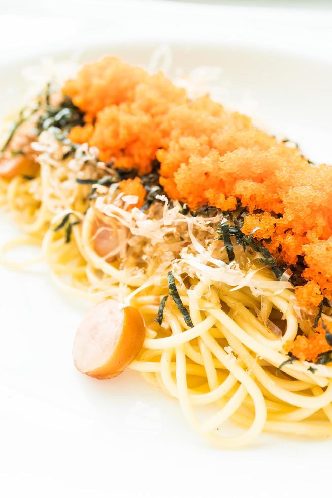 espaguete com linguiça, ovo de camarão, alga, lula seca por cima foto