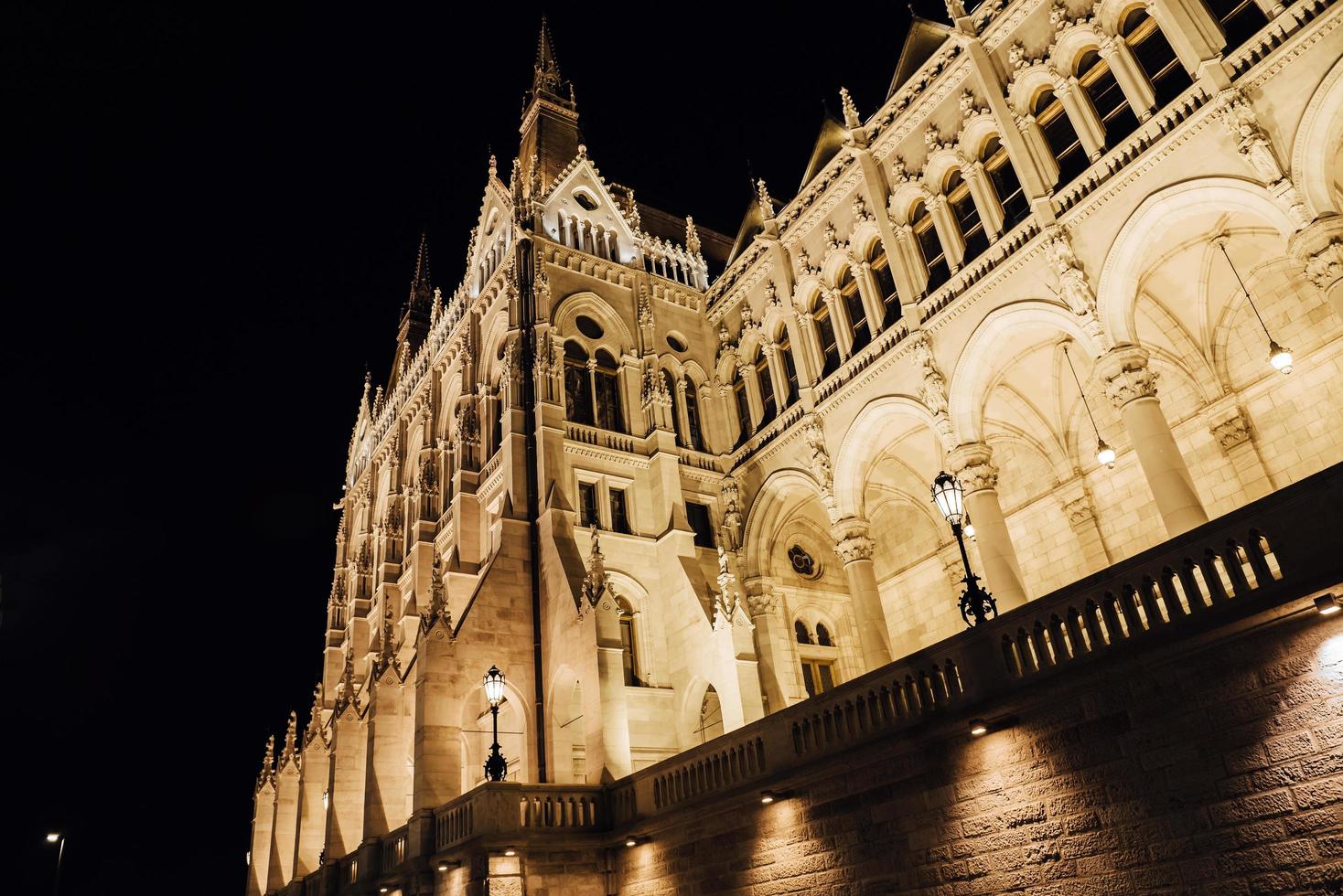 o parlamento húngaro em Budapeste, no Danúbio, à luz noturna dos postes de luz foto