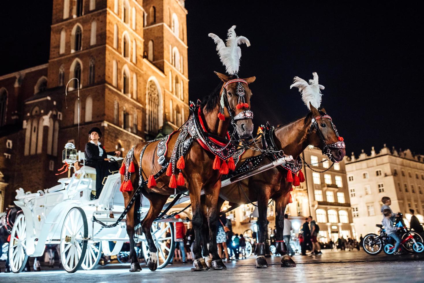 Cracóvia, Polônia 2017 - a antiga praça da noite em Cracóvia com carruagens puxadas por cavalos foto