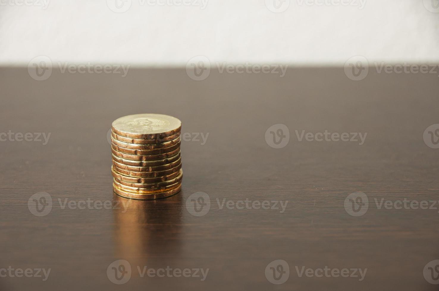dourado moedas pilha em de madeira mesa - crescimento conceito foto