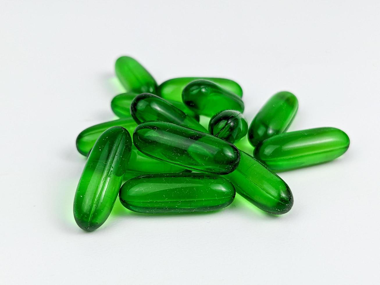 verde transparente cápsula pílulas do Vitamina e isolado em branco fundo foto