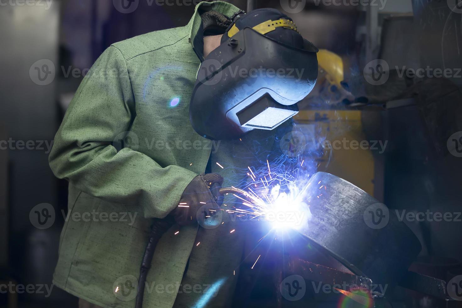 uma soldador dentro uma protetora capacete soldas a ferro costura. foto