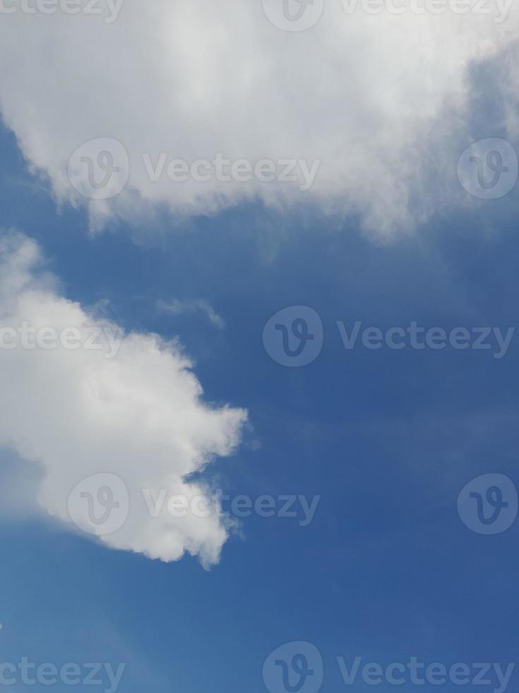 lindas nuvens brancas sobre fundo de céu azul profundo. grandes nuvens fofas e brilhantes cobrem todo o céu azul. foto