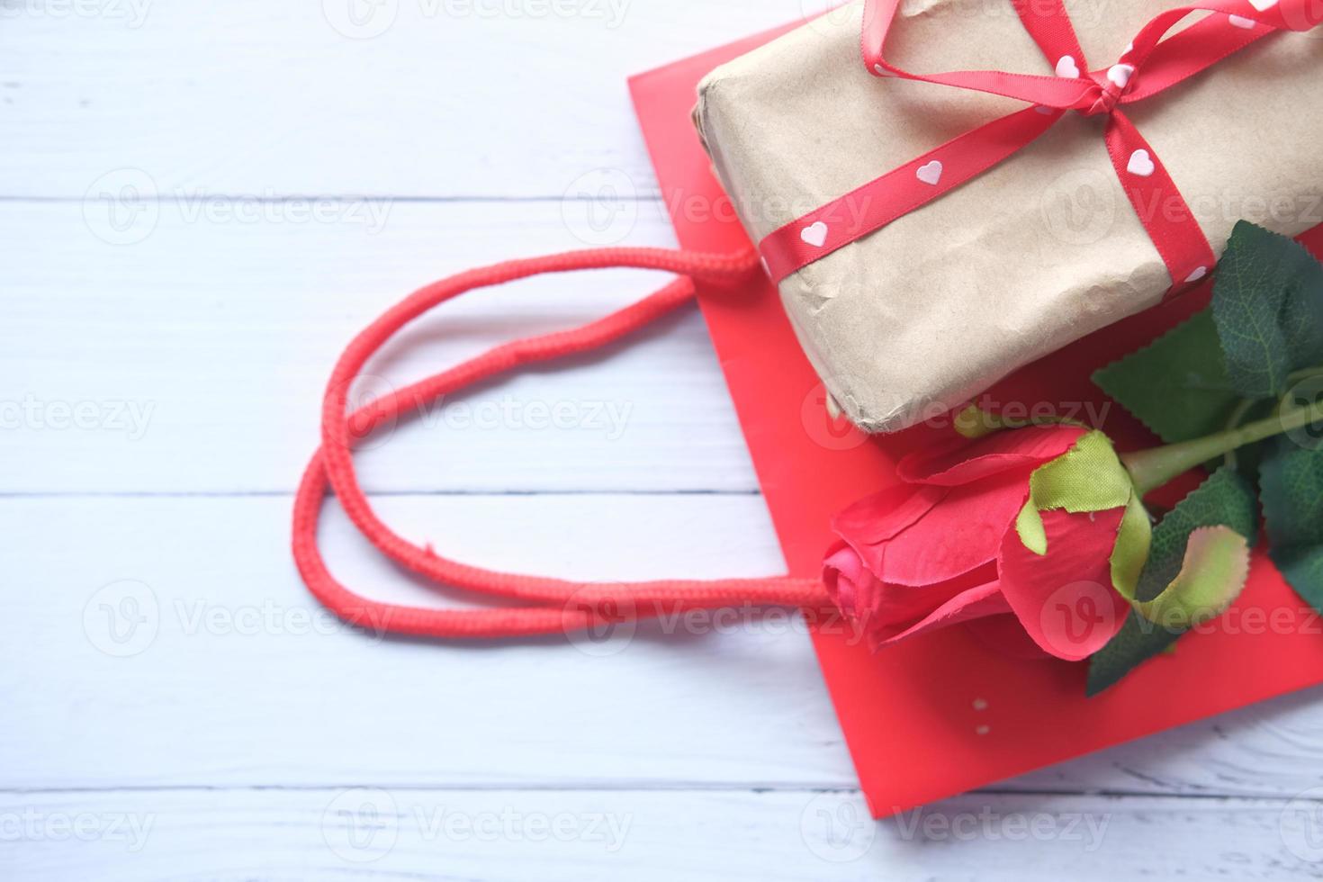 vista superior de uma caixa de presente, bolsa e rosas sobre a mesa foto