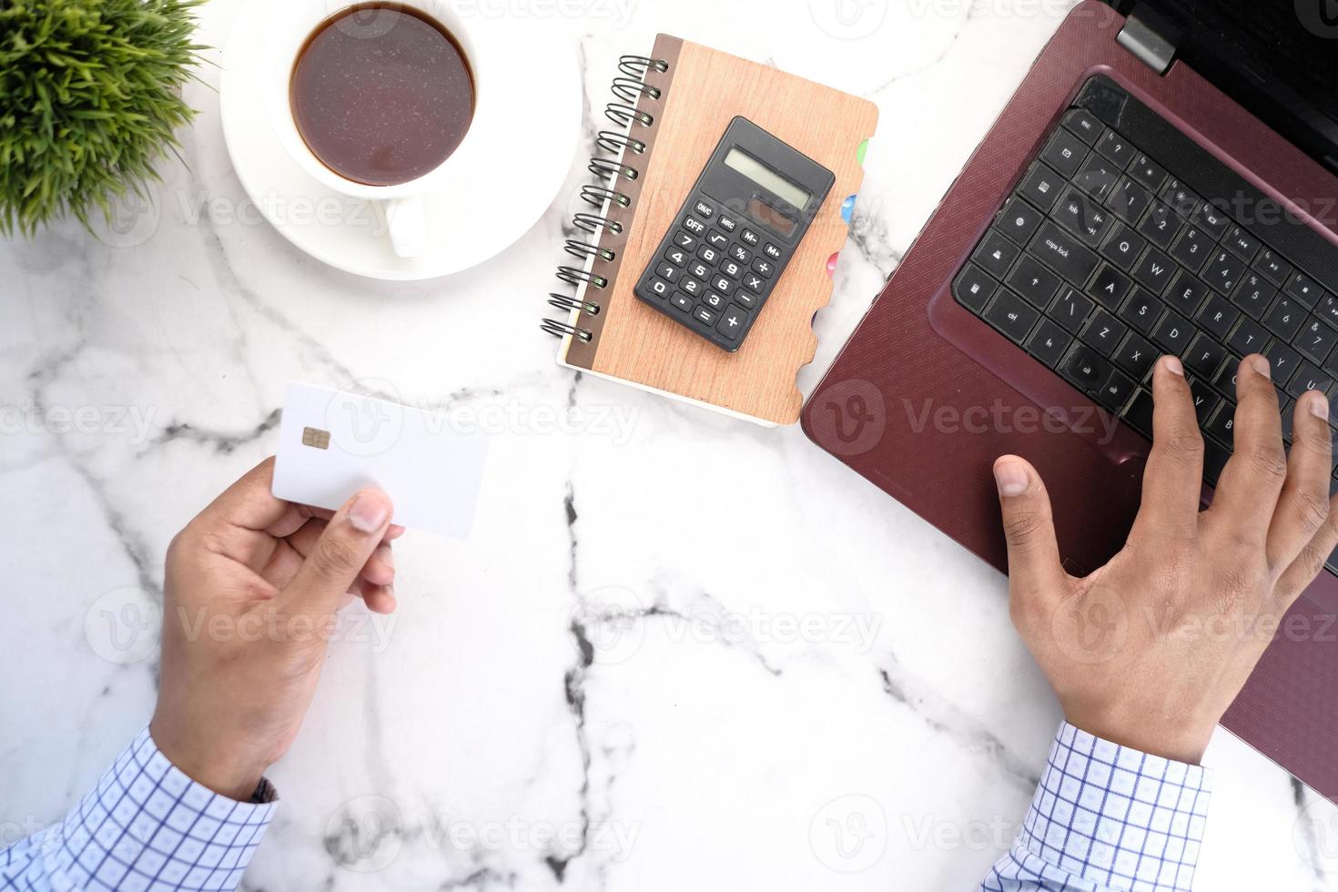 pessoa usando um cartão de crédito branco para fazer compras online foto