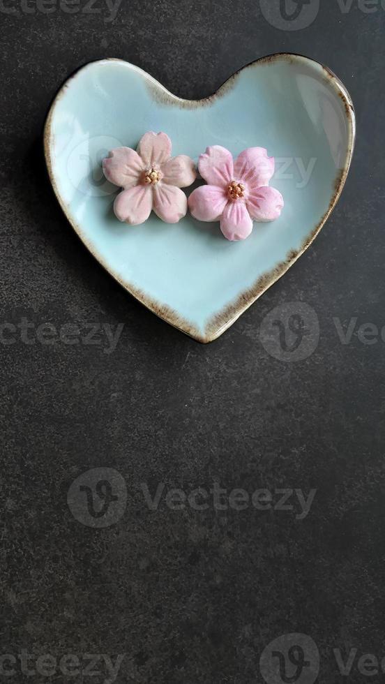 coco leite sabor, pastel Rosa cor, sam panela nee tradicional tailandês feito â mão lanche em pastel azul coração forma placa, Sombrio fundo, vertical imagem com cópia de espaço foto