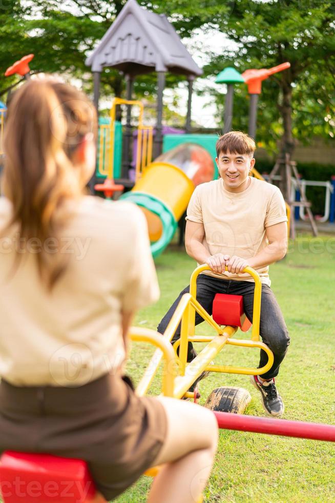 casal asiático adora brincar gangorra foto