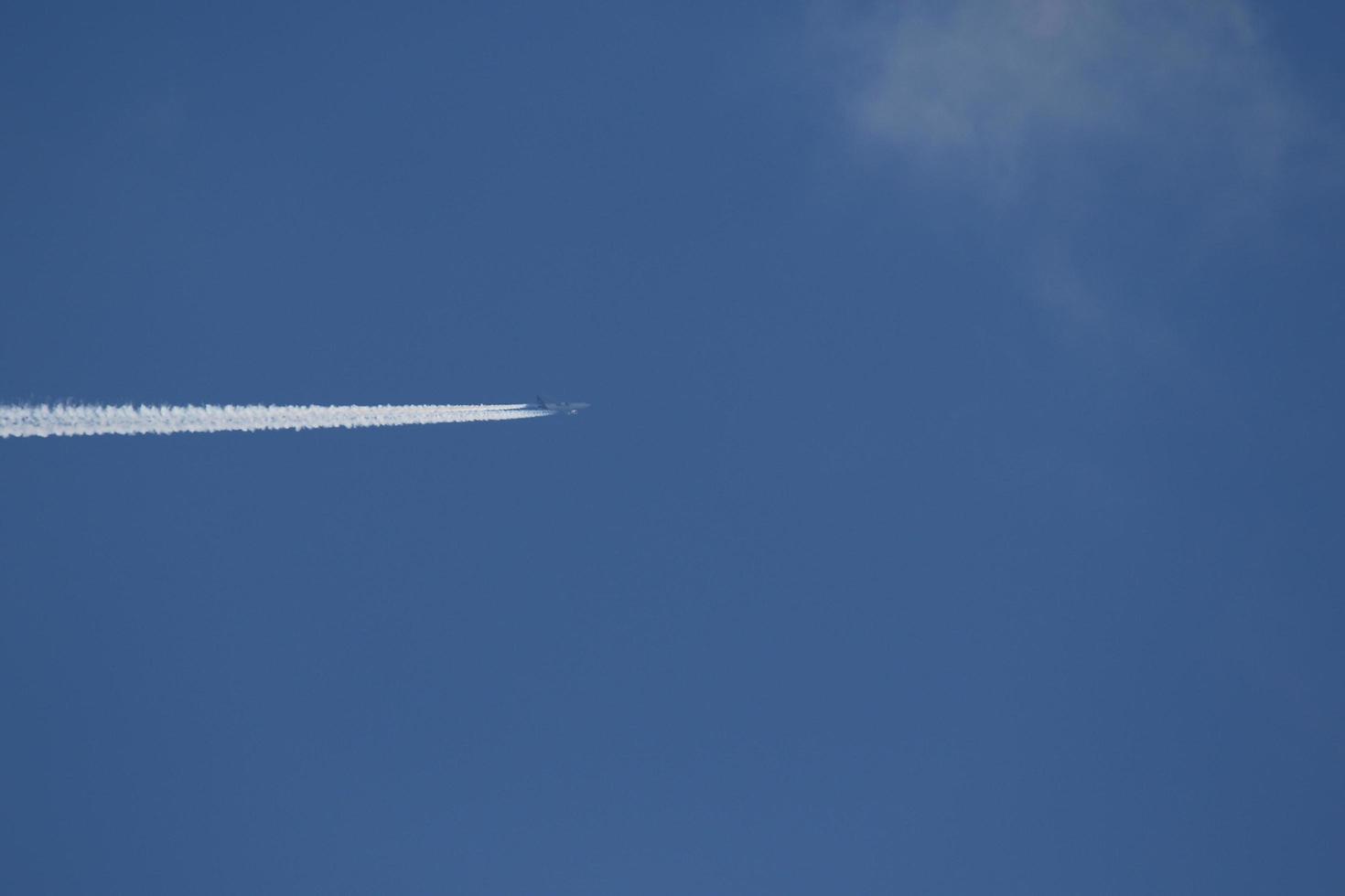 um avião e trilhas de vapor no céu foto