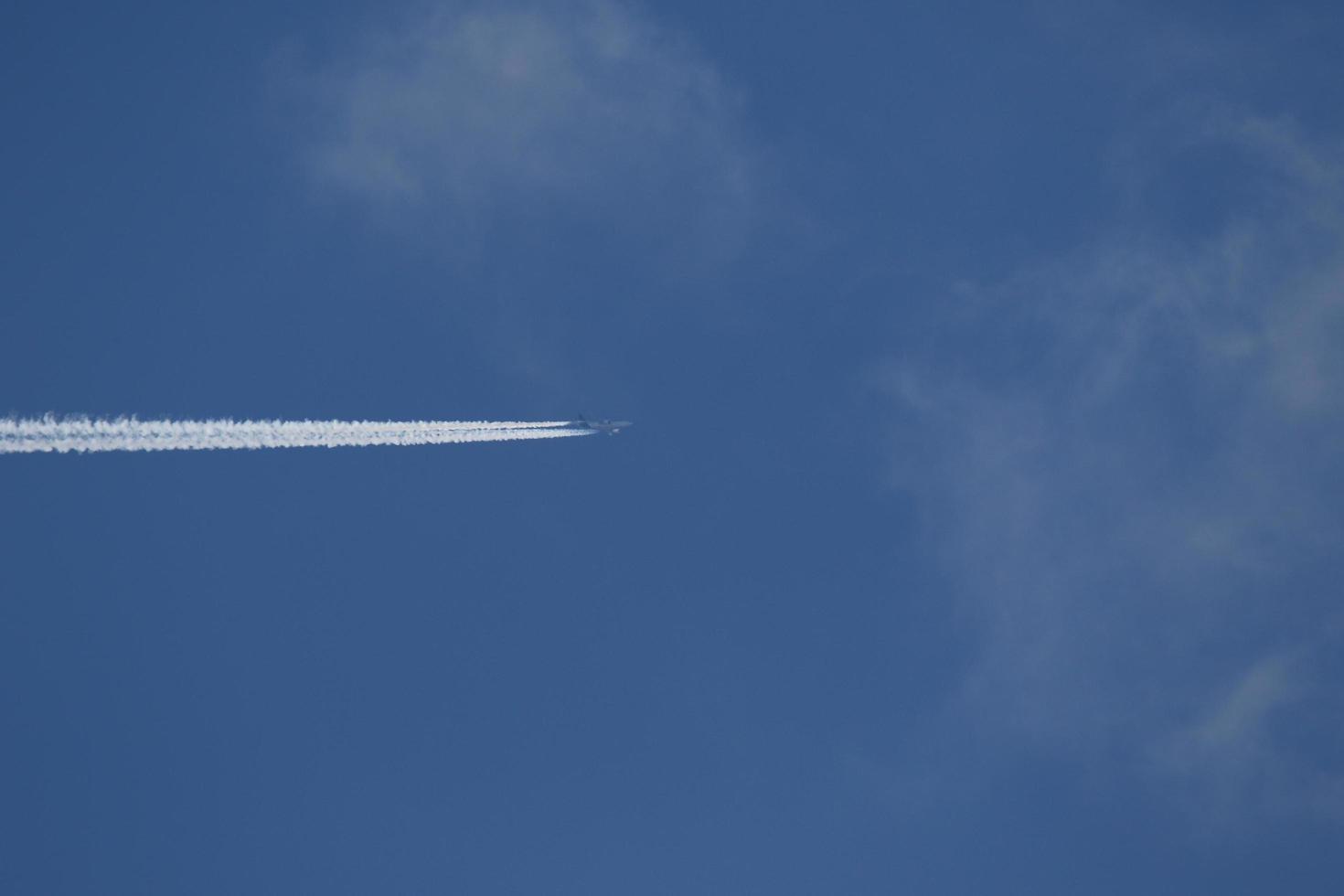 um avião e trilhas de vapor no céu foto