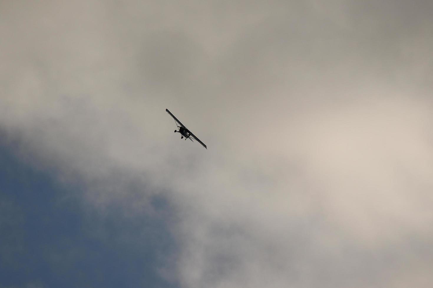 pequeno avião vôo dentro a céu contra Sombrio nuvens foto