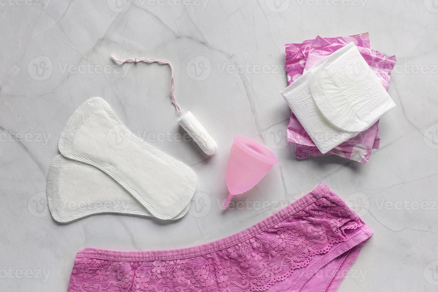 Rosa calça com sanitário guardanapos, absorvente interno, menstrual copo em branco fundo. conceito do crítico dias, menstruação foto