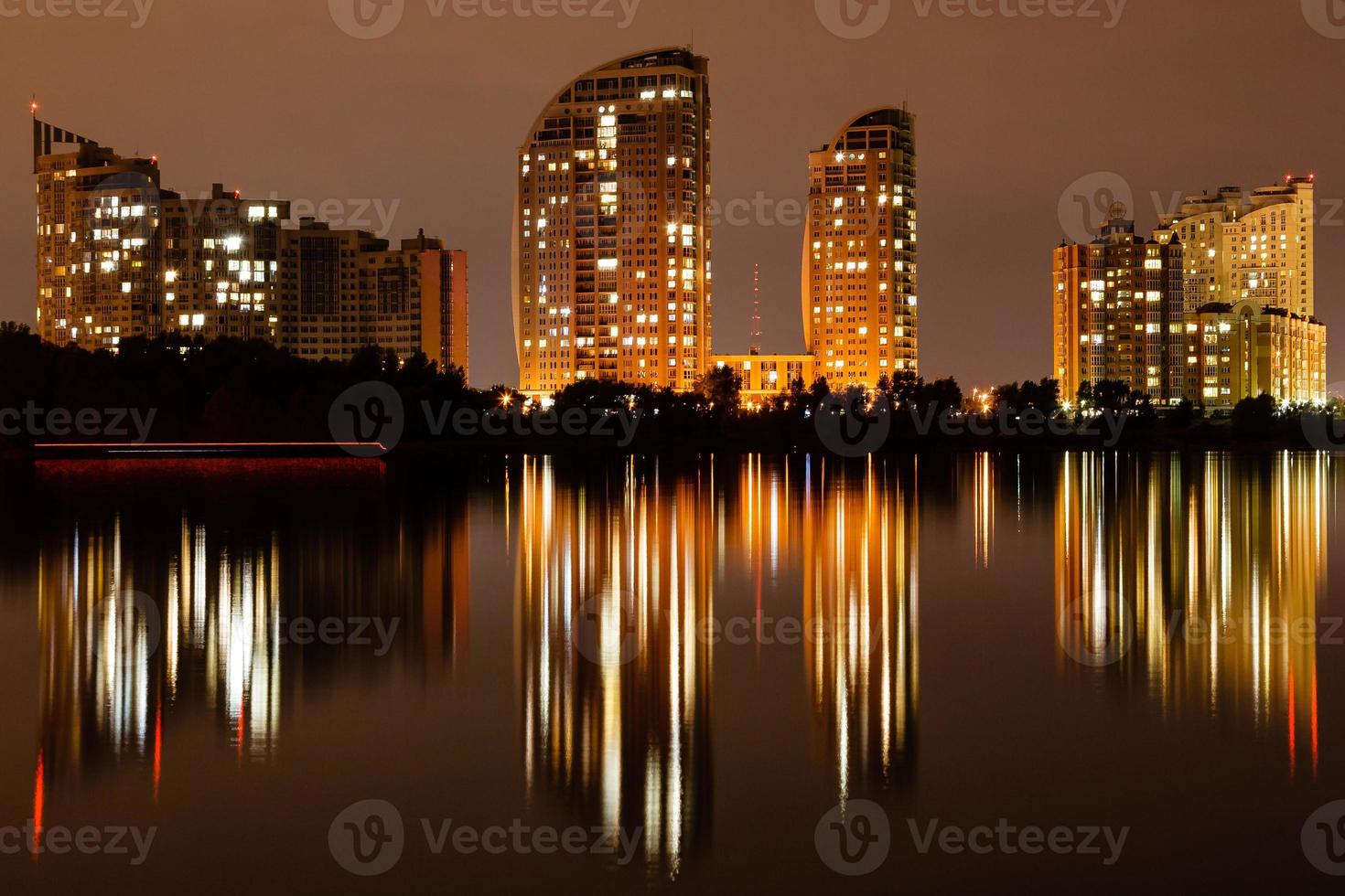 cidade noturna com reflexo de casas no rio foto