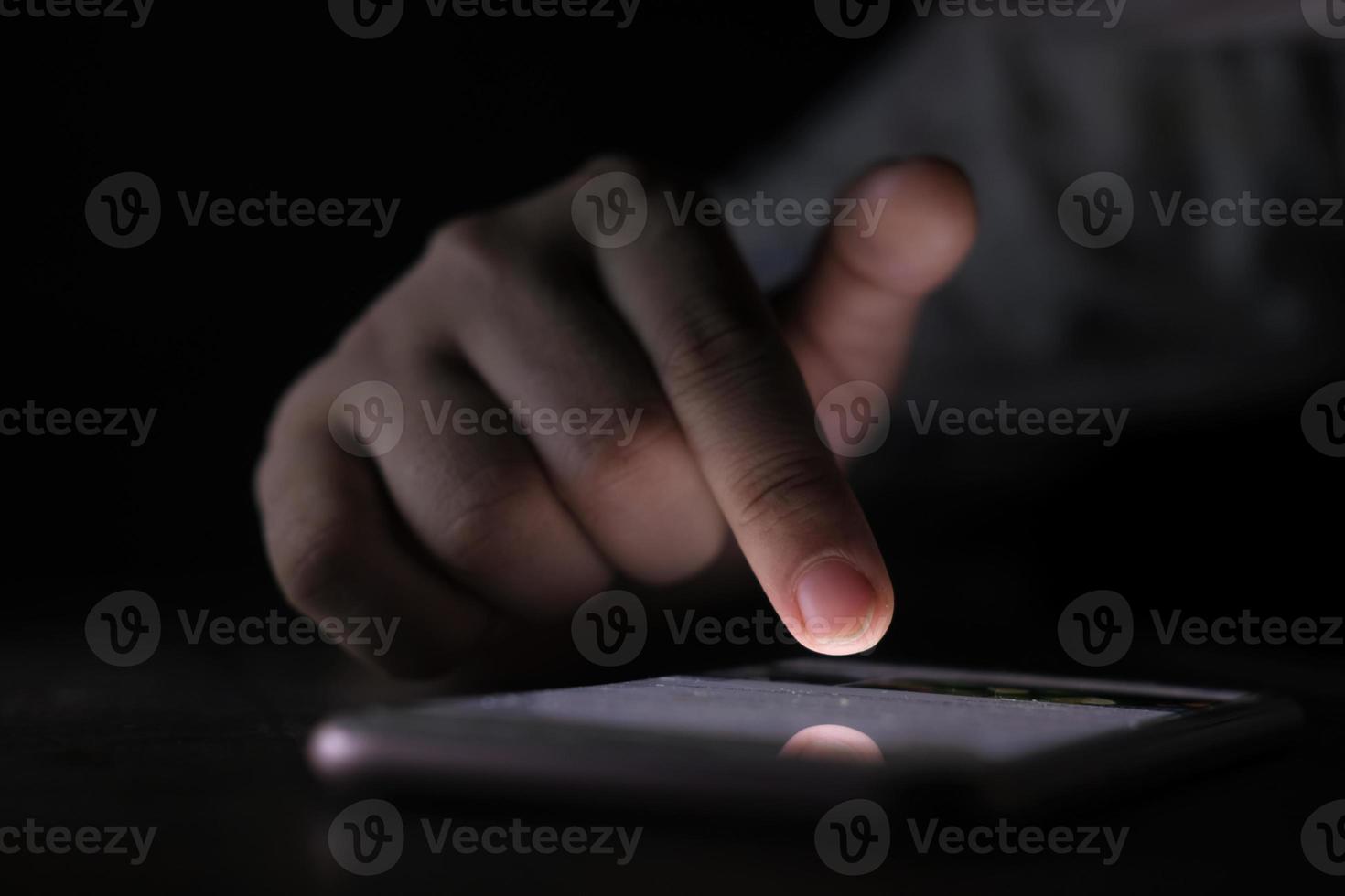 feche a mão de uma mulher usando um telefone inteligente à noite foto