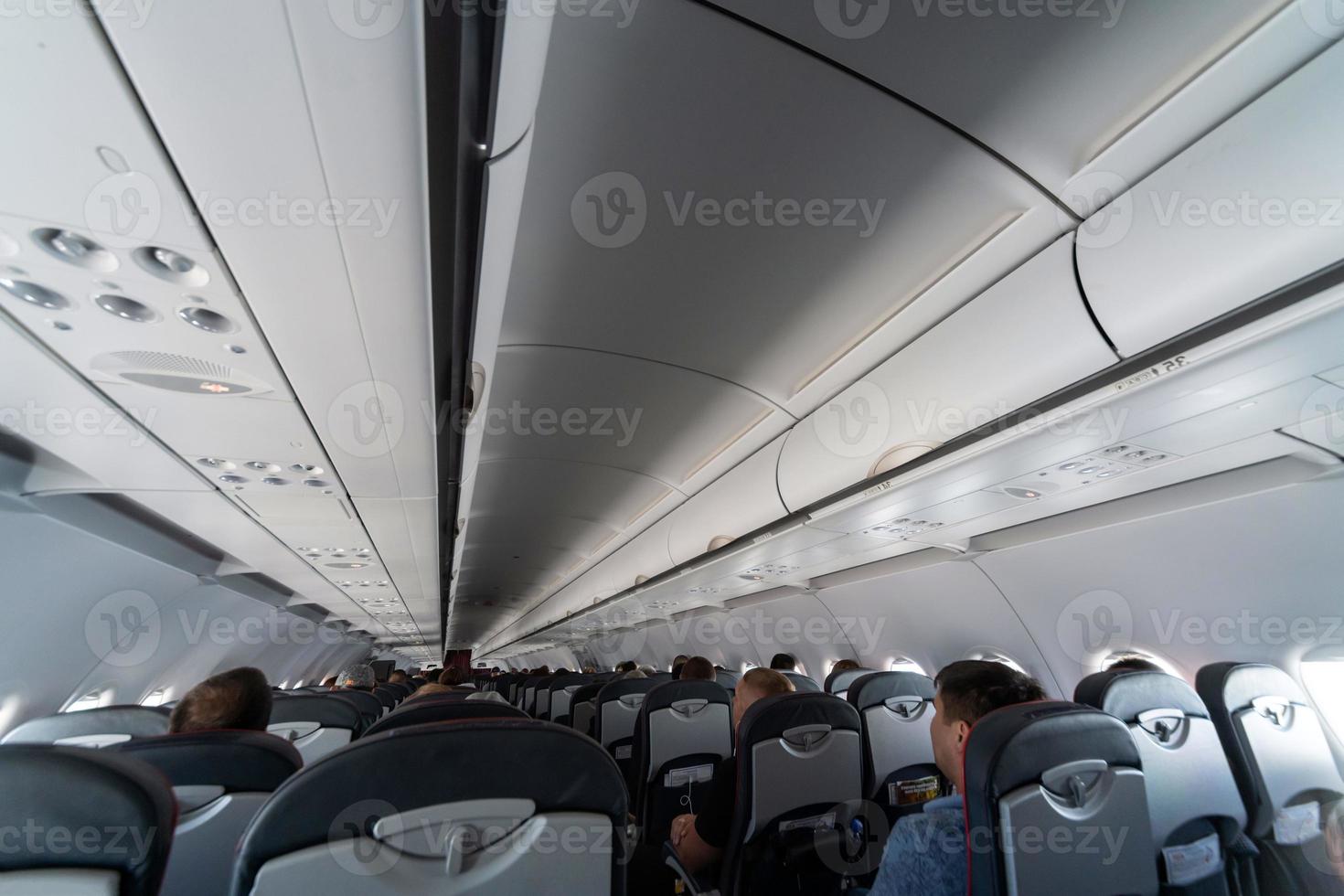 assentos de cabine de avião com passageiros. classe econômica de novas companhias aéreas de baixo custo mais baratas sem atraso ou cancelamento de voo. viagem de viagem para outro país. foto