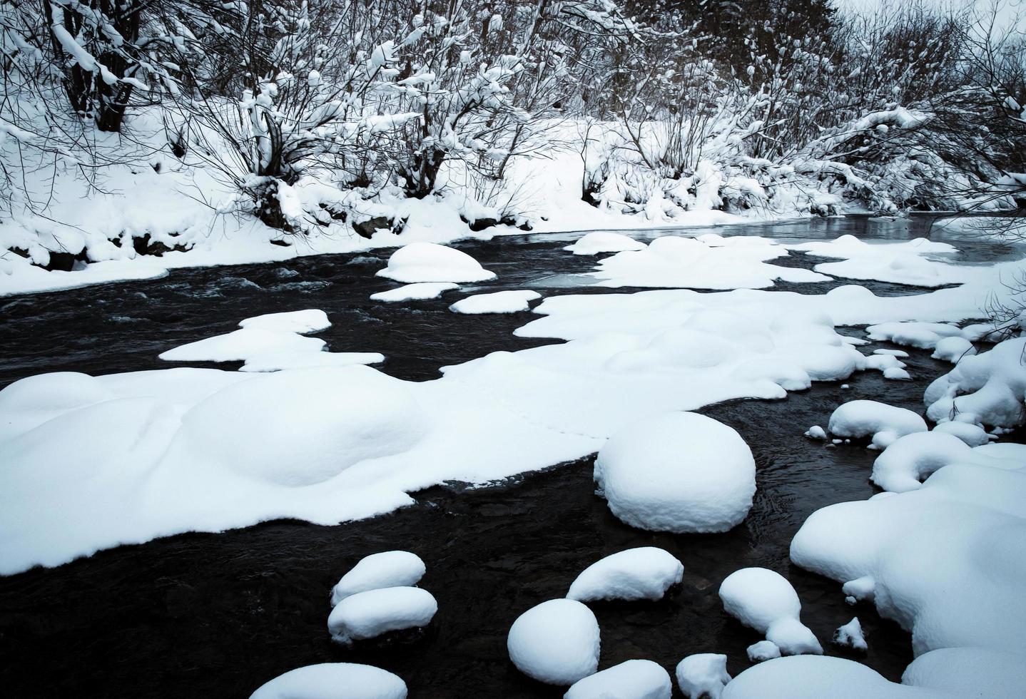 rio de inverno com mantas de neve fresca foto