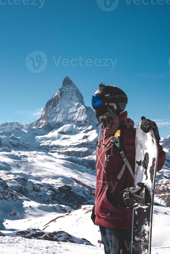 jovem snowboarder gastos inverno feriados dentro zermatt, perto a famoso matterhorn pico. masculino posando dentro suíço Alpes para a snowboard temporada. foto