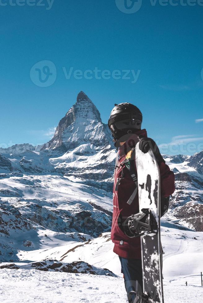 jovem snowboarder gastos inverno feriados dentro zermatt, perto a famoso matterhorn pico. masculino posando dentro suíço Alpes para a snowboard temporada. foto