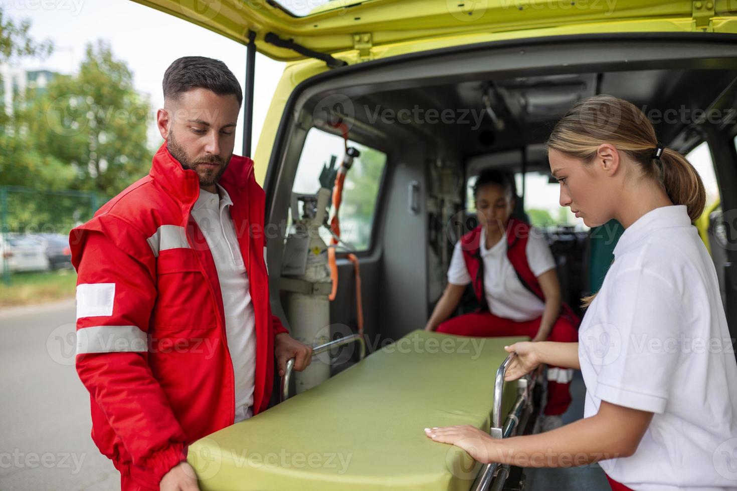 paramédicos comovente Fora ambulância maca a partir de carro. paramédicos rolando a ambulância maca foto