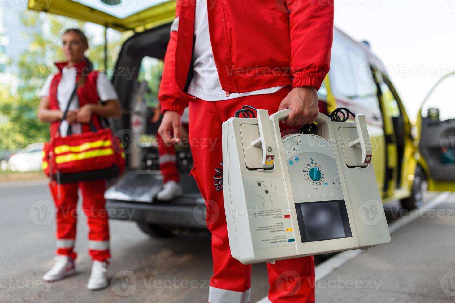 mão do a médico com desfibrilador. equipes do a emergência médico serviço estão respondendo para a tráfego acidente. foto