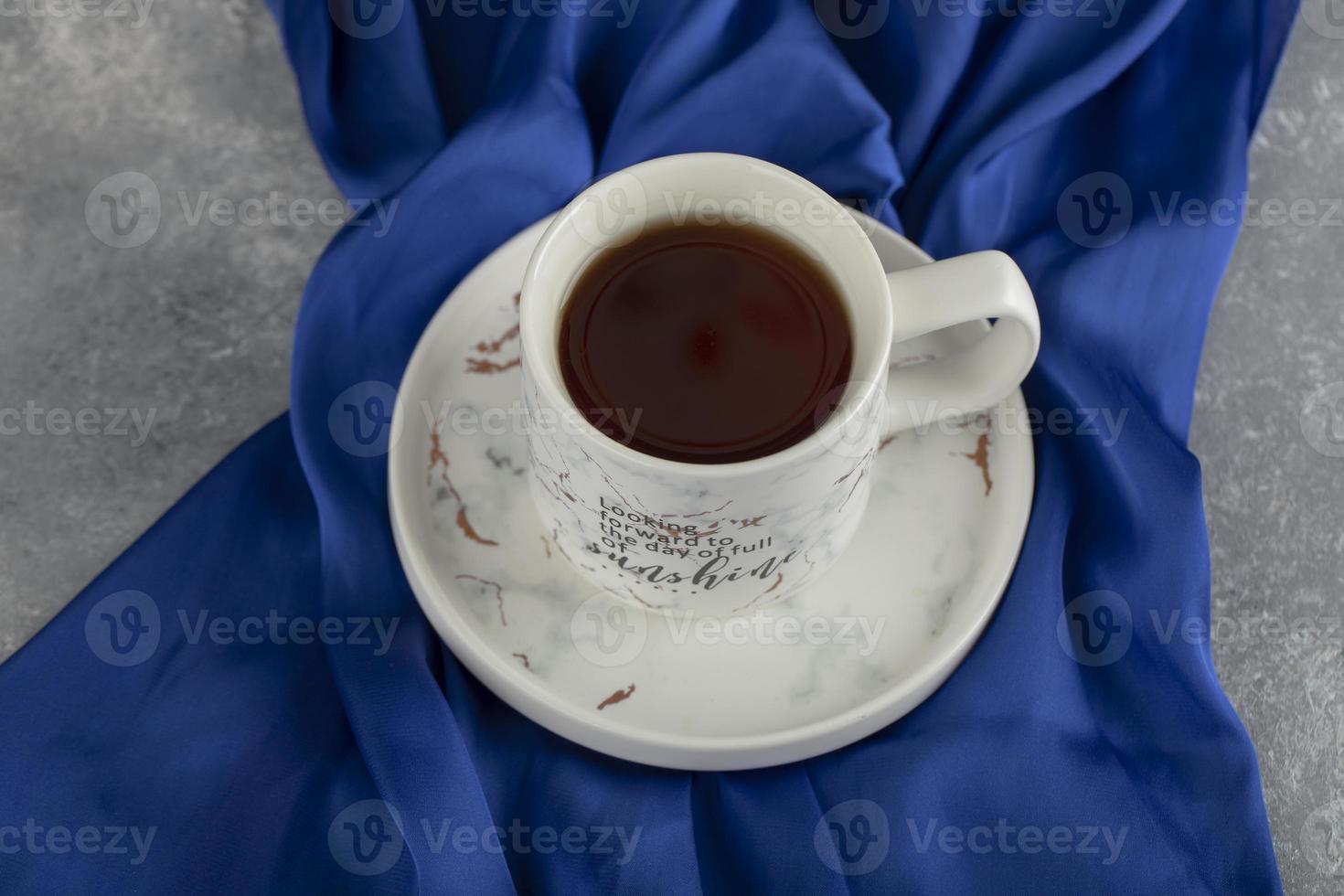 uma xícara de cerâmica branca em uma toalha de mesa azul foto