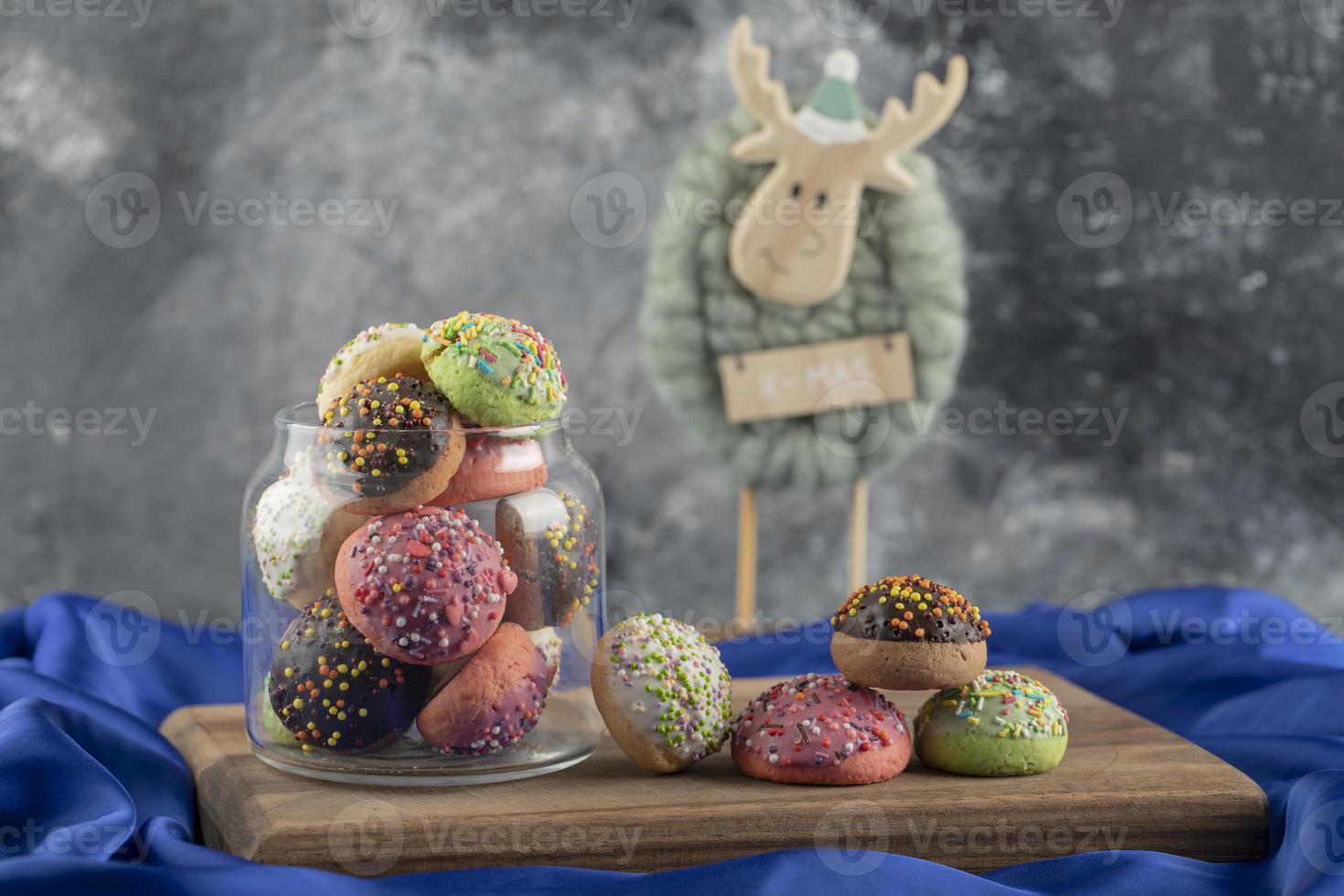 Donuts doces coloridos com um brinquedo de cervo de natal foto
