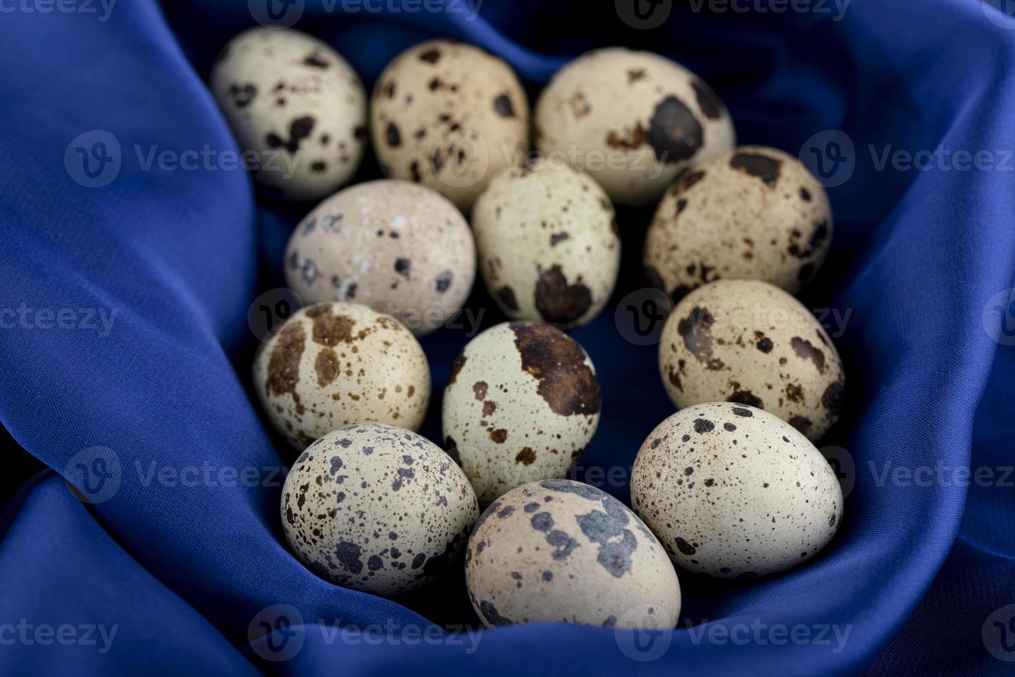 Ovos de codorna frescos em um pano de cetim azul foto