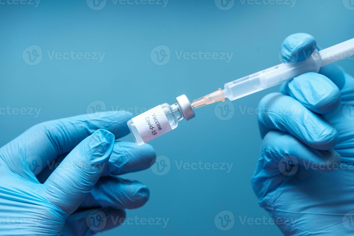 médico segurando seringa e vacina foto
