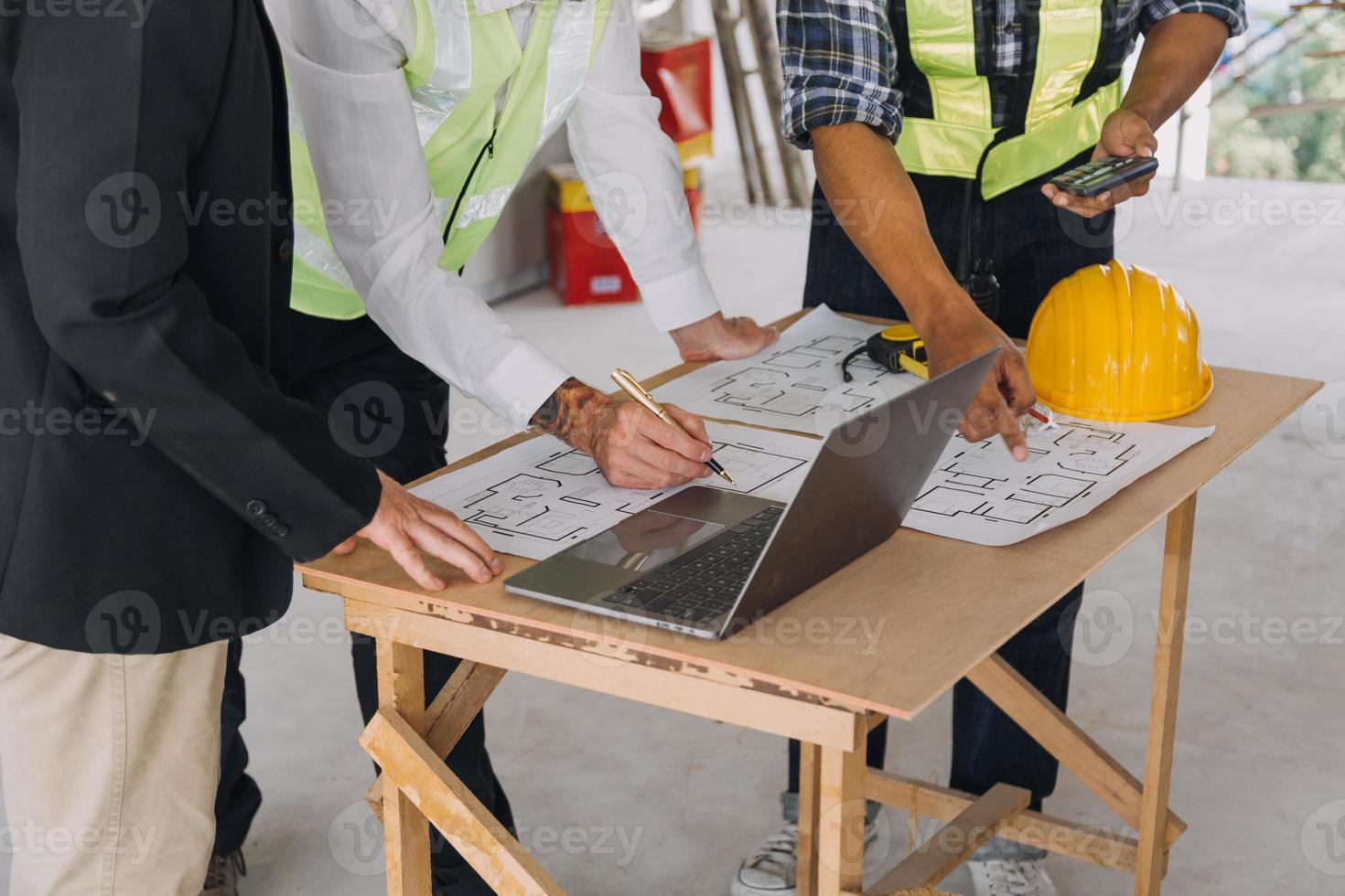 diverso equipe do especialistas usar tábua computador em construção local. real Estado construção projeto com Civil engenheiro, arquiteto, o negócio investidor e geral trabalhador discutindo plano detalhes. foto