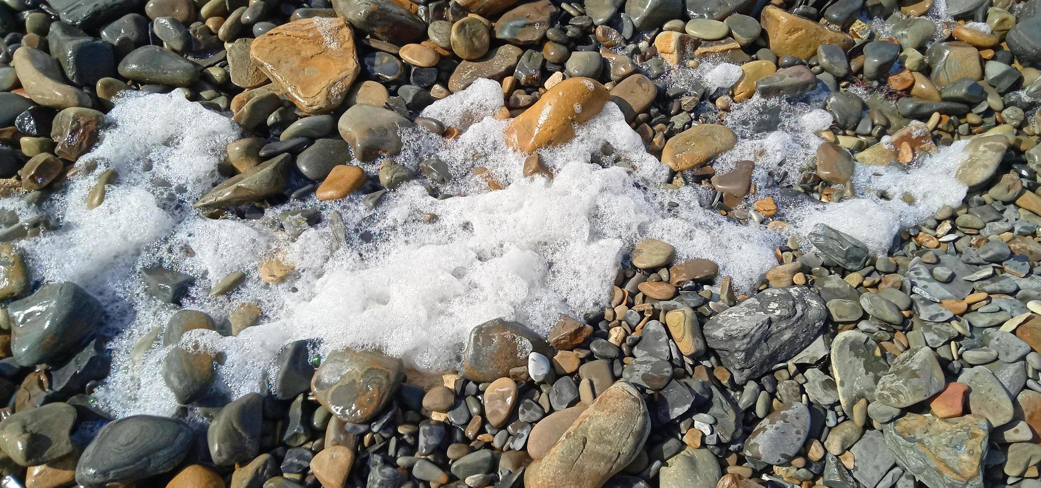 pedras debaixo água em a de praia foto