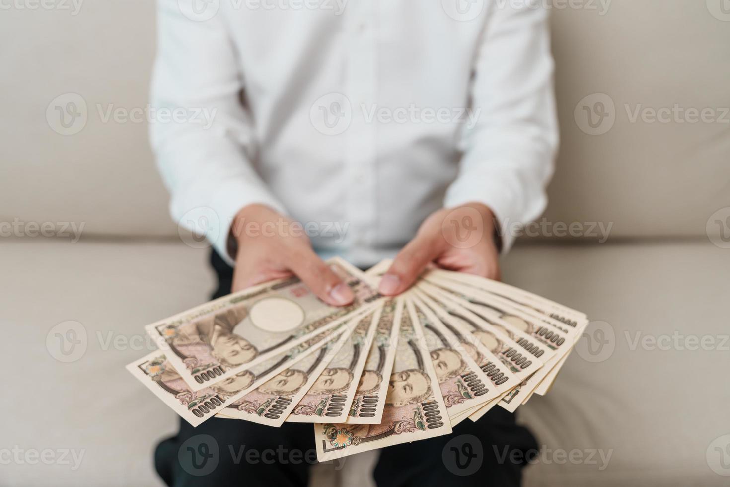 mão de homem segurando a pilha de notas de iene japonês. dinheiro de mil ienes. dinheiro do japão, impostos, economia de recessão, inflação, investimento, finanças e conceitos de pagamento de compras foto