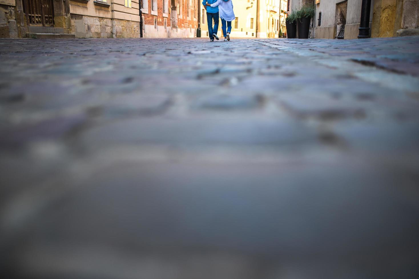 um rapaz e uma rapariga numa velha rua de paralelepípedos na europa foto