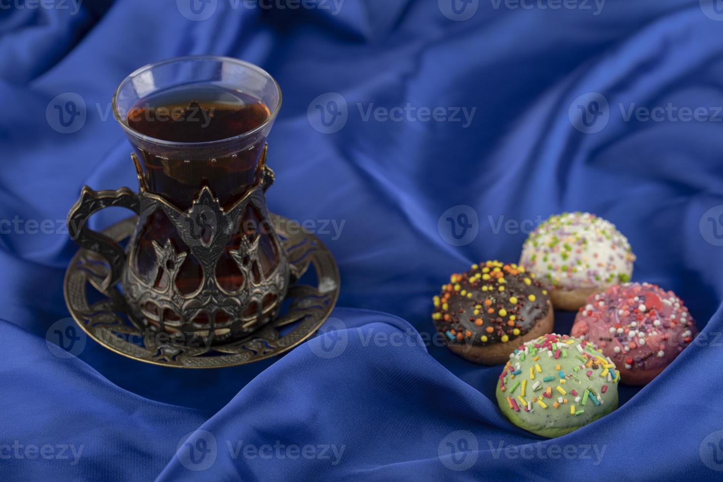 rosquinhas doces coloridas com uma xícara de chá foto