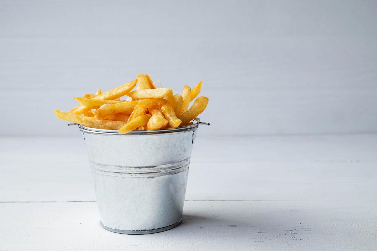 balde e cesta de batatas fritas foto