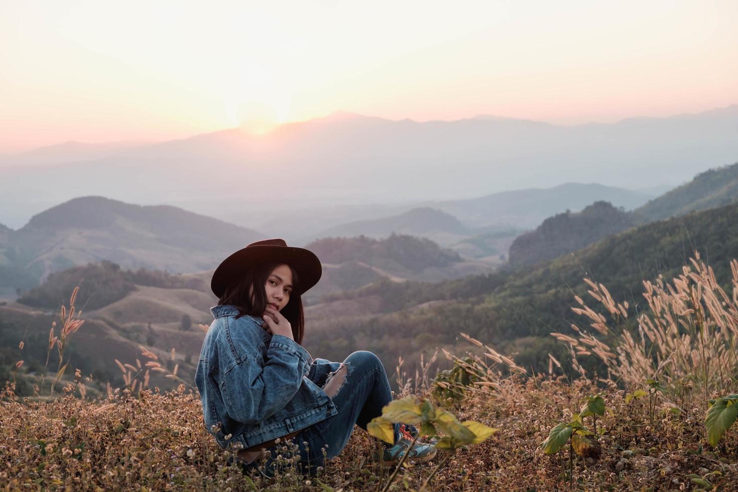 mulher sentada no topo de uma montanha foto