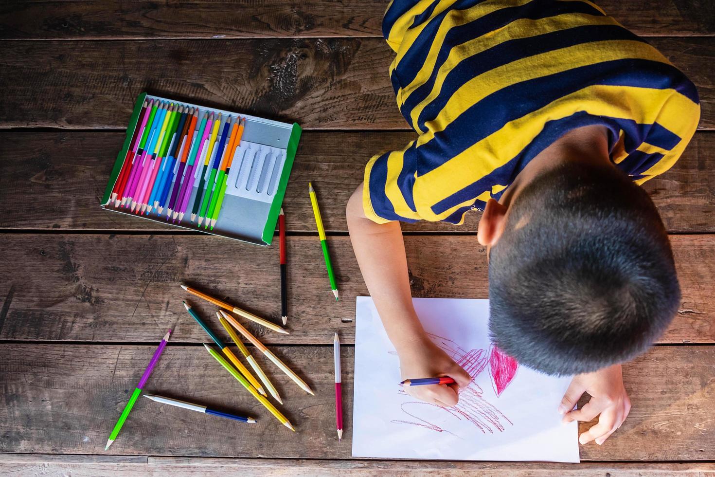 menino desenhando com lápis de colorir foto
