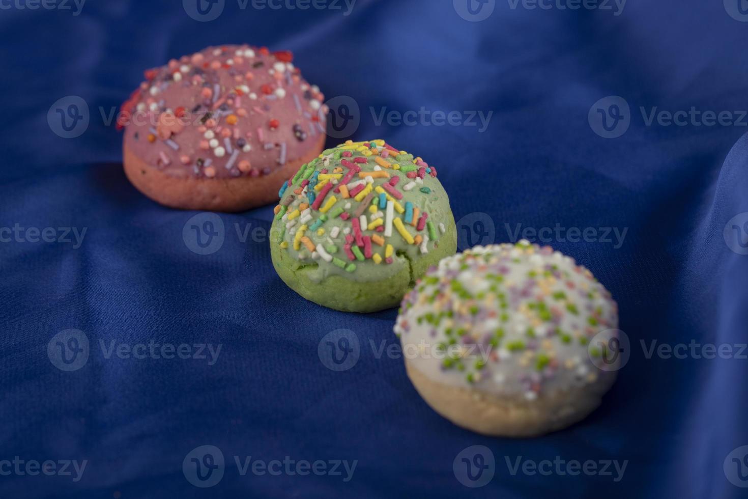 conjunto colorido de pequenos donuts doces em um fundo azul foto