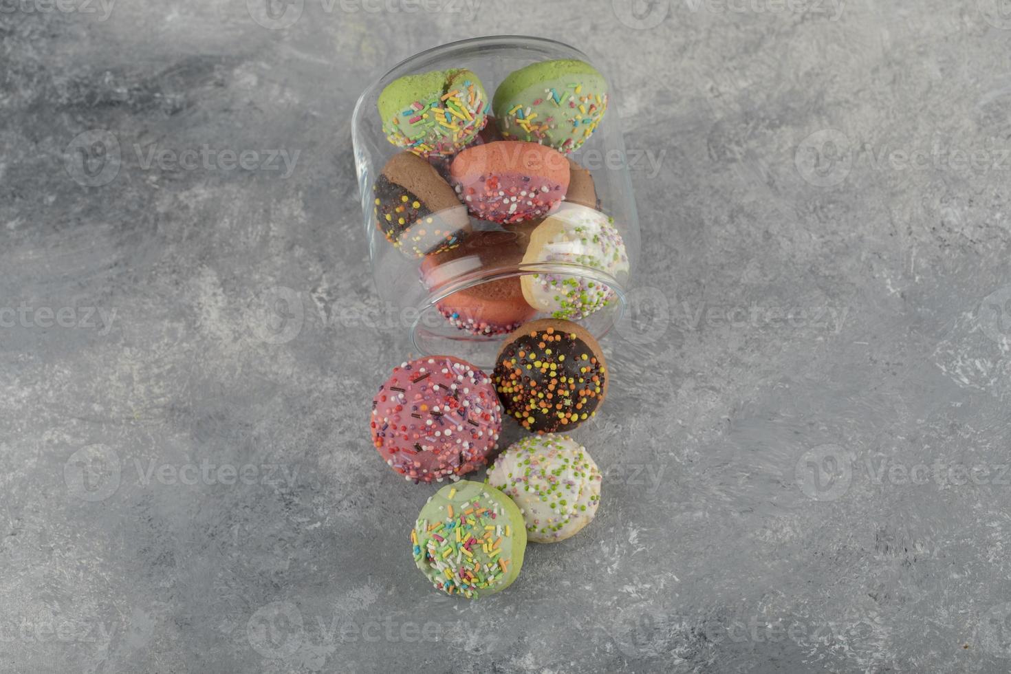uma jarra de vidro cheia de pequenos donuts coloridos foto