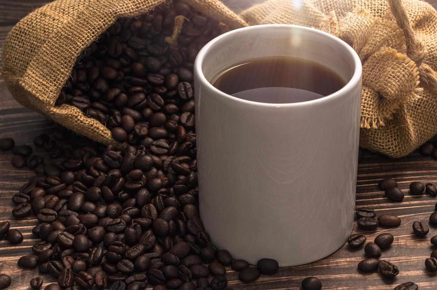 uma caneca de café e grãos de café em uma mesa de madeira, conceito de café de amor foto