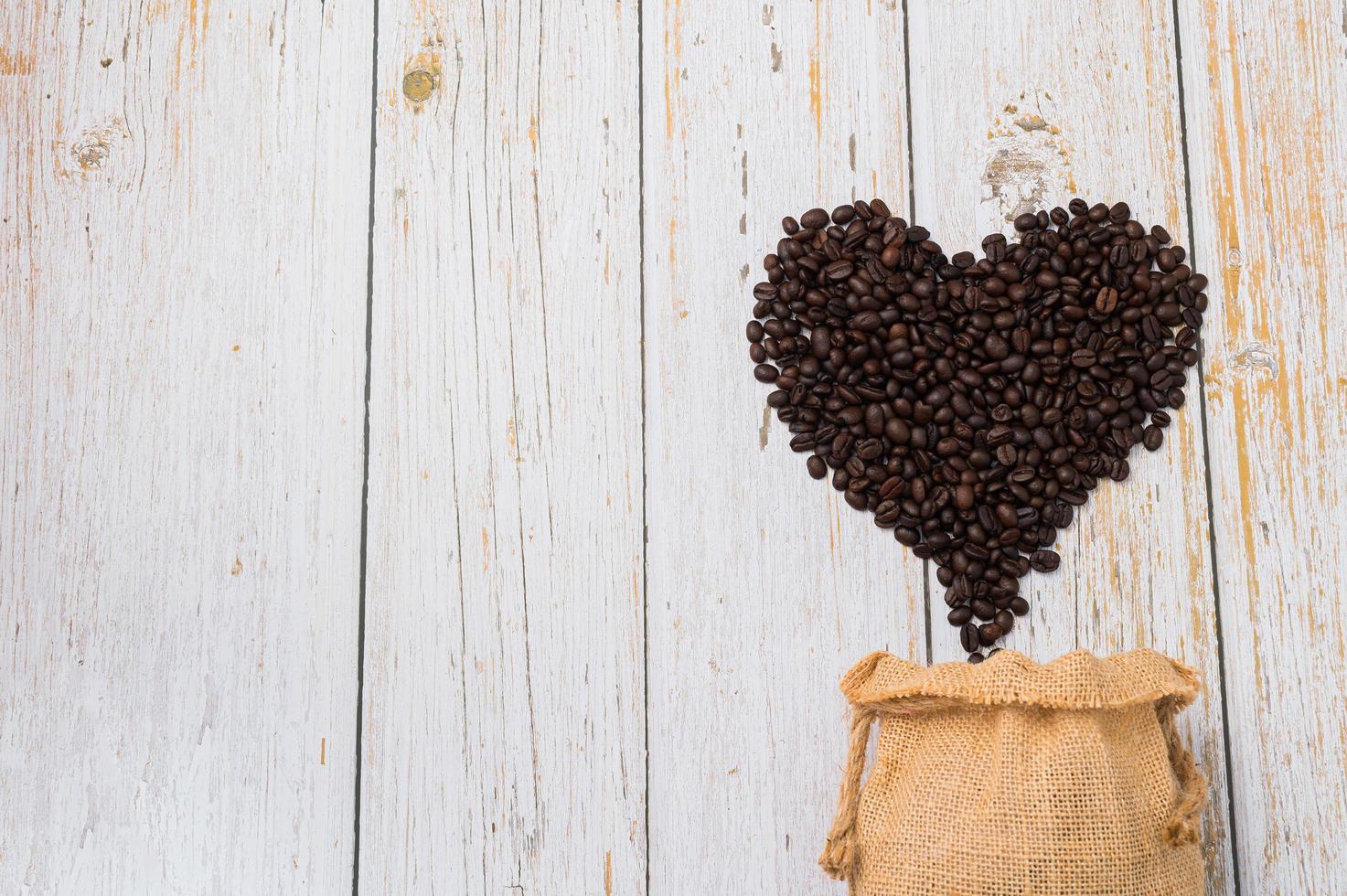 grãos de café dispostos em forma de coração, adoro beber café conceito foto