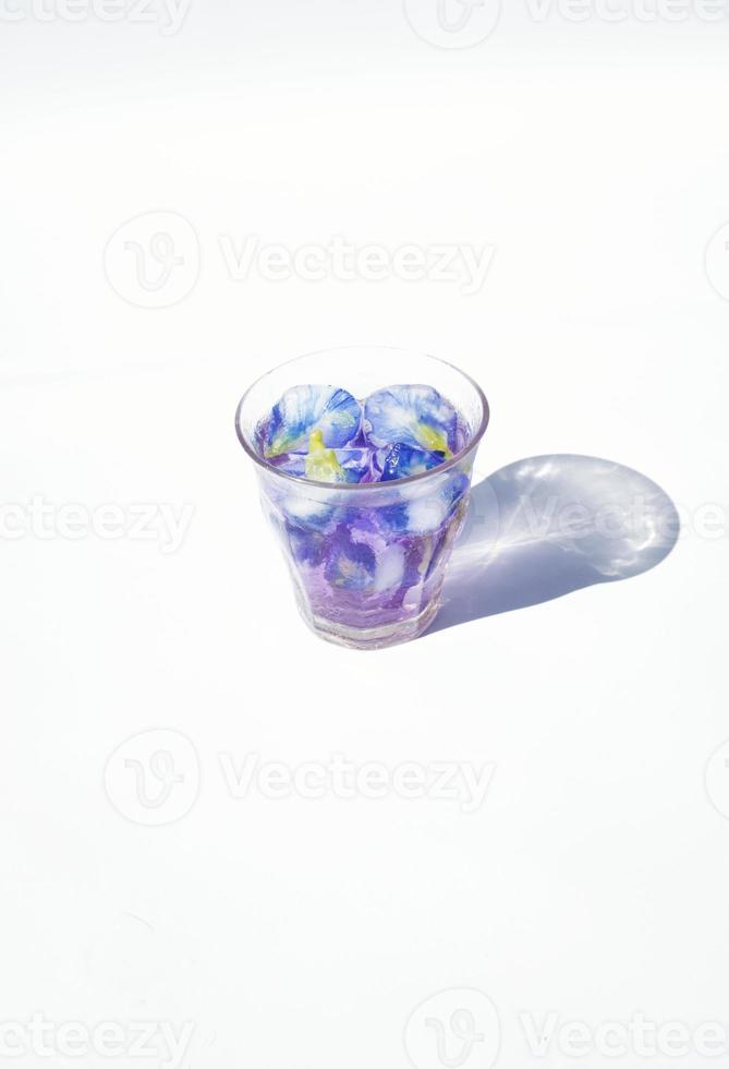 vidro do roxa chá com gelo cubo em branco fundo foto