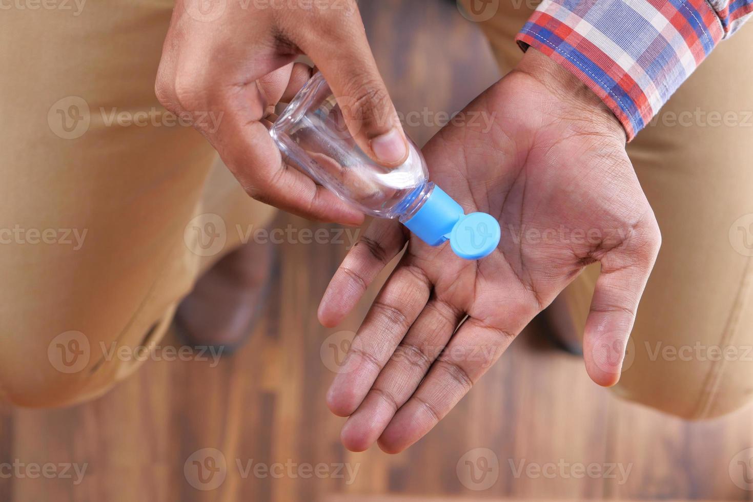 close-up do homem usando desinfetante para as mãos foto