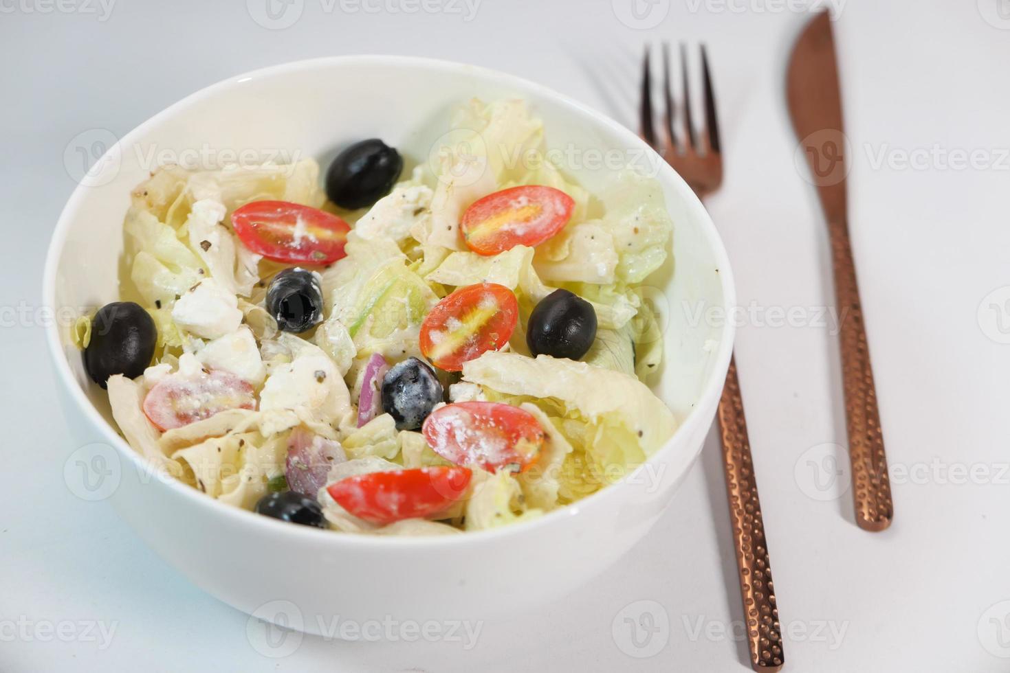 close up de salada grega em uma tigela na mesa foto