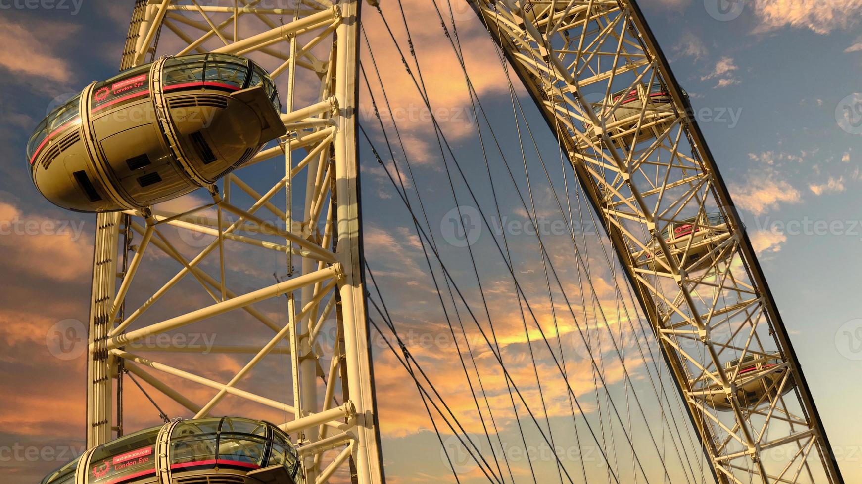 ferris roda dentro a diversão parque em fundo do pôr do sol céu com nuvens. baixo ângulo Visão do uma grande ferris roda. foto