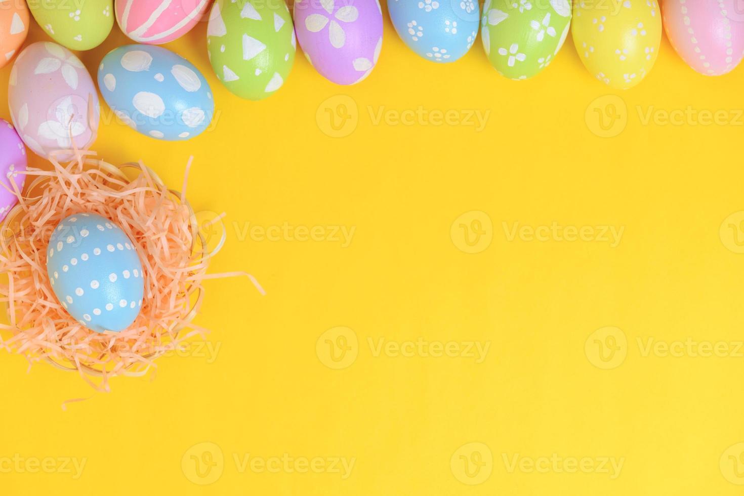 feliz Páscoa celebração feriado. colorida pastel pintado ovos dentro vime cesta ninho decoração em uma amarelo fundo. sazonal cumprimento presente cartão conceito. topo visualizar, plano deitar, cópia de espaço. foto