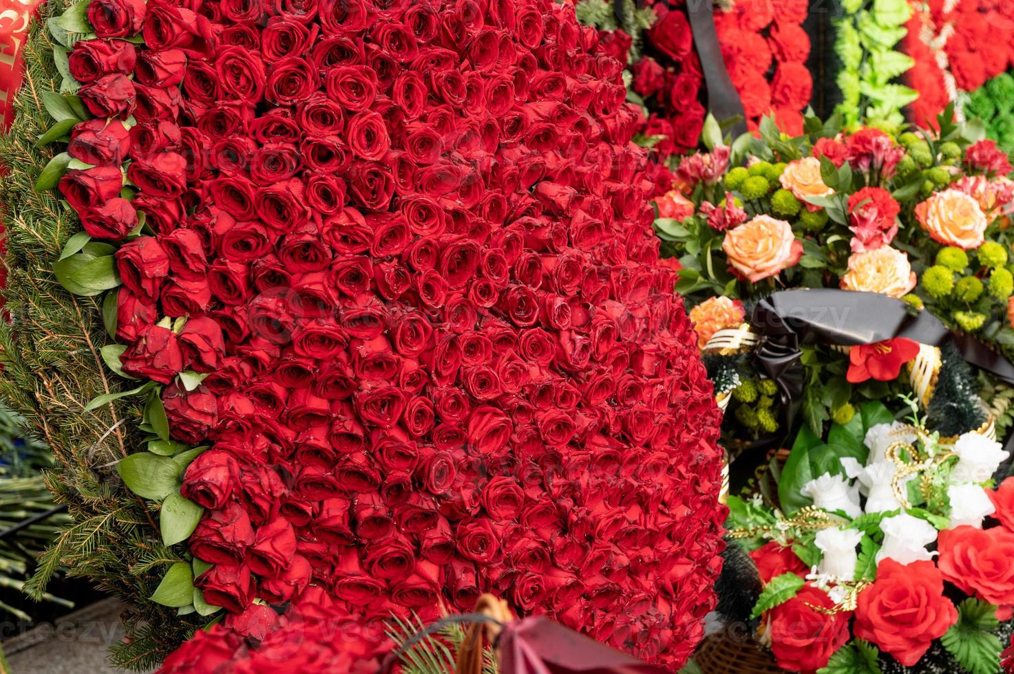 uma guirlanda do vermelho vivo rosas é liderar às a monumento em a rua. dia do lembrança e tristeza. foto