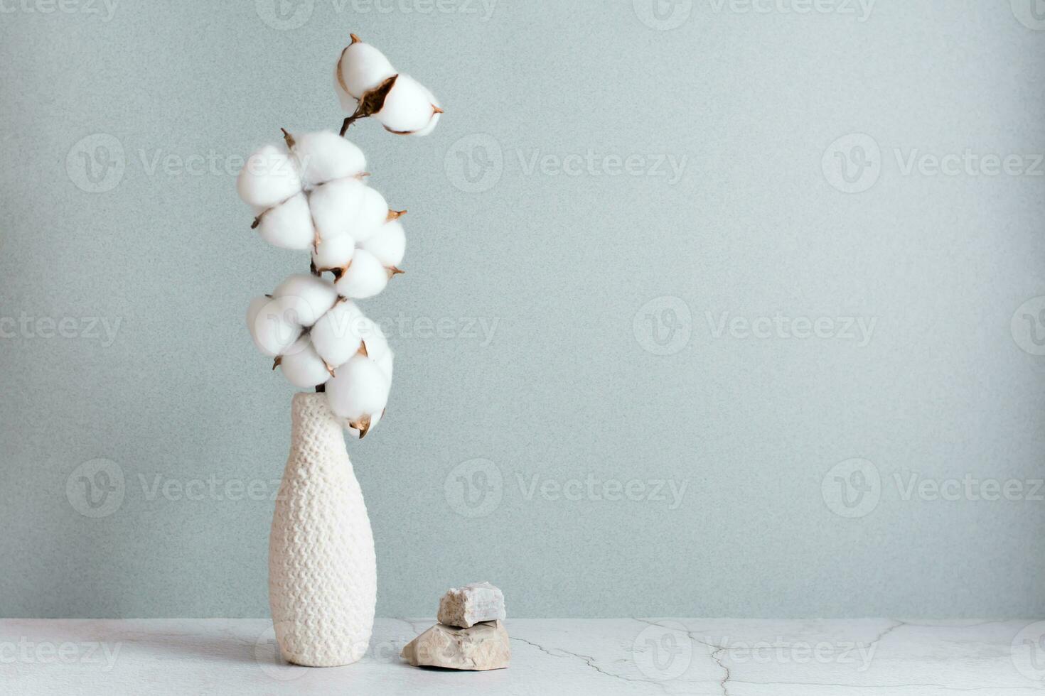 eco amigáveis casa decoração algodão ramo dentro vaso e pedras em mesa em cinzento fundo. cópia de espaço foto