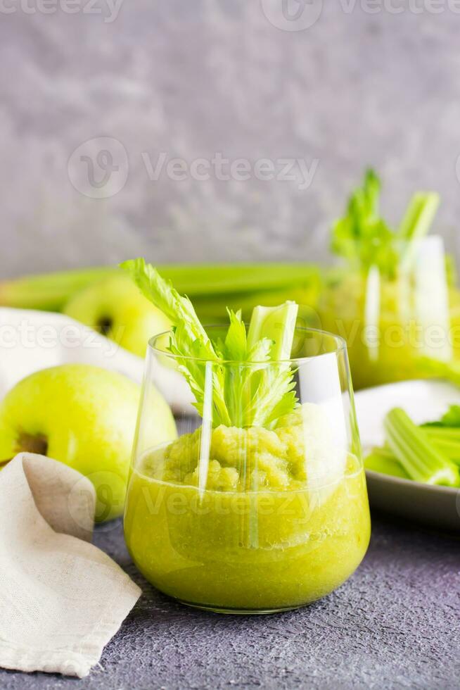 fresco salsão e verde maçã batido dentro óculos e cozinhando ingredientes em a mesa. vegetariano dieta desintoxicação Comida. vertical visualizar. cópia de espaço foto