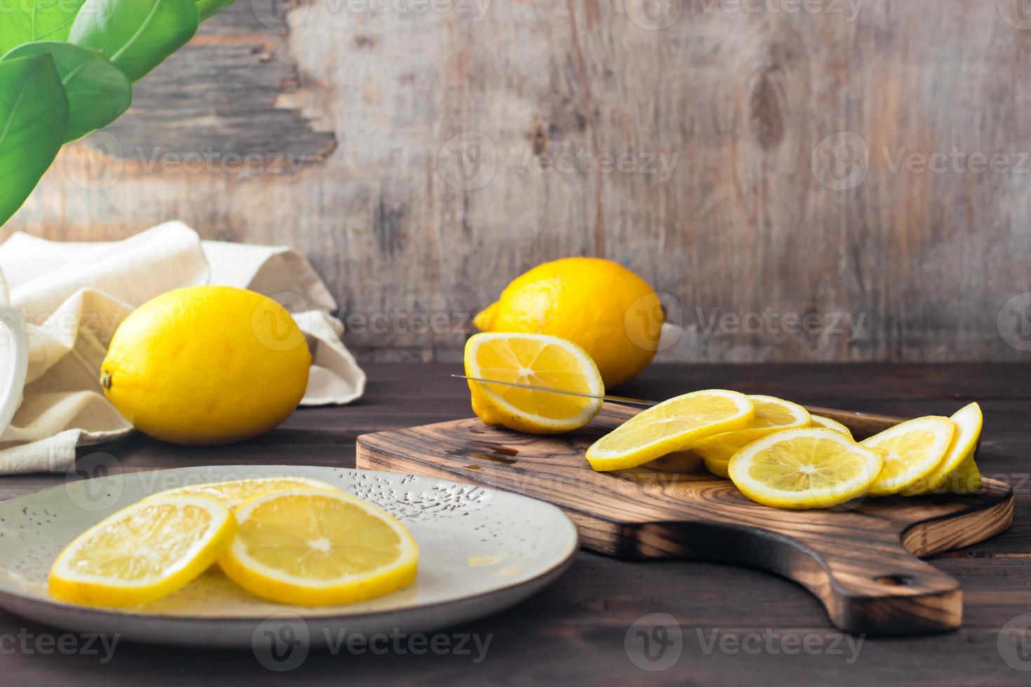 corte maduro limões em uma de madeira corte borda e peças em uma prato em a mesa. orgânico nutrição, fonte do vitaminas. foto