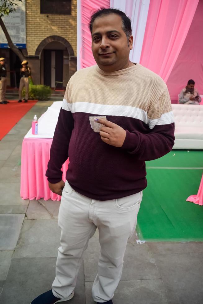 nova delhi, índia - 04 de dezembro de 2022 - pessoas não identificadas mostrando seus dedos marcados com tinta depois de votar em frente à cabine de votação da área de leste de delhi para as eleições do corpo local mcd 2022 foto