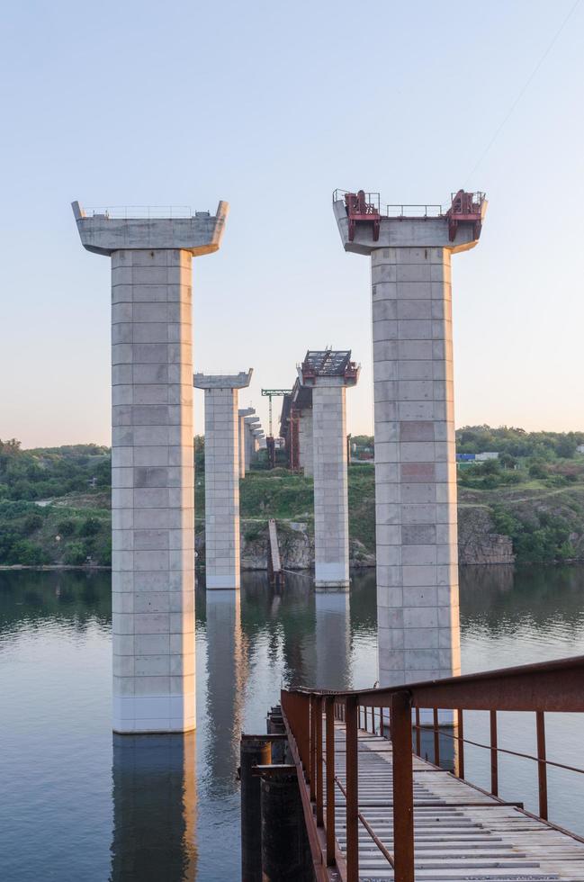 ponte em construção com guindaste rodoviário e pilares foto
